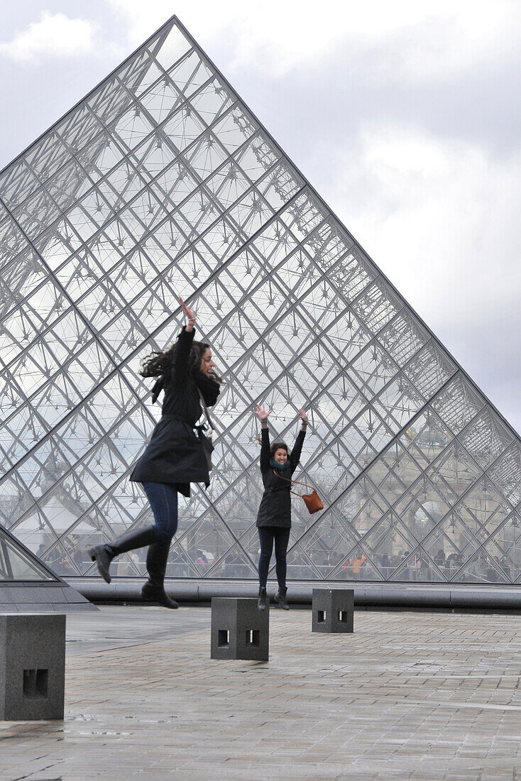 Two young women near the Louvre pyramid, Paris, France