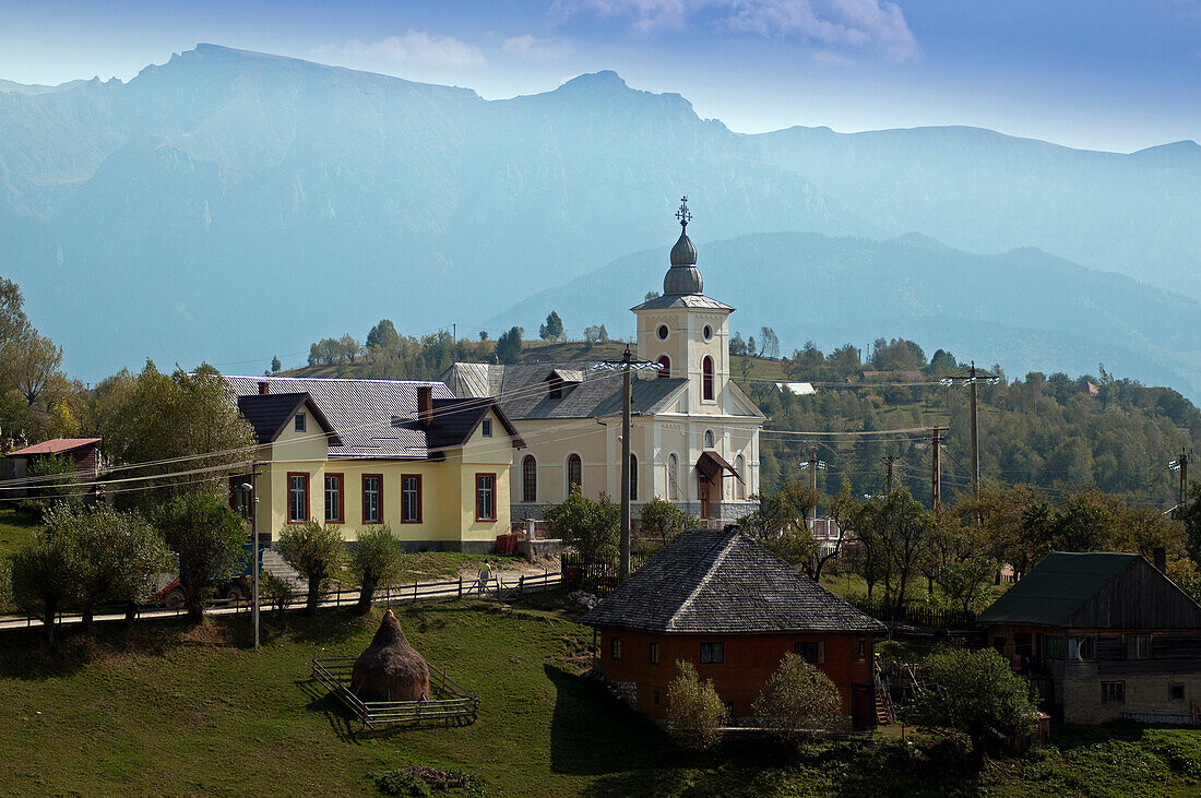 Church in the village of Magura, with the Bucegi Mountains in the background, Magura, Transylvania, Romania