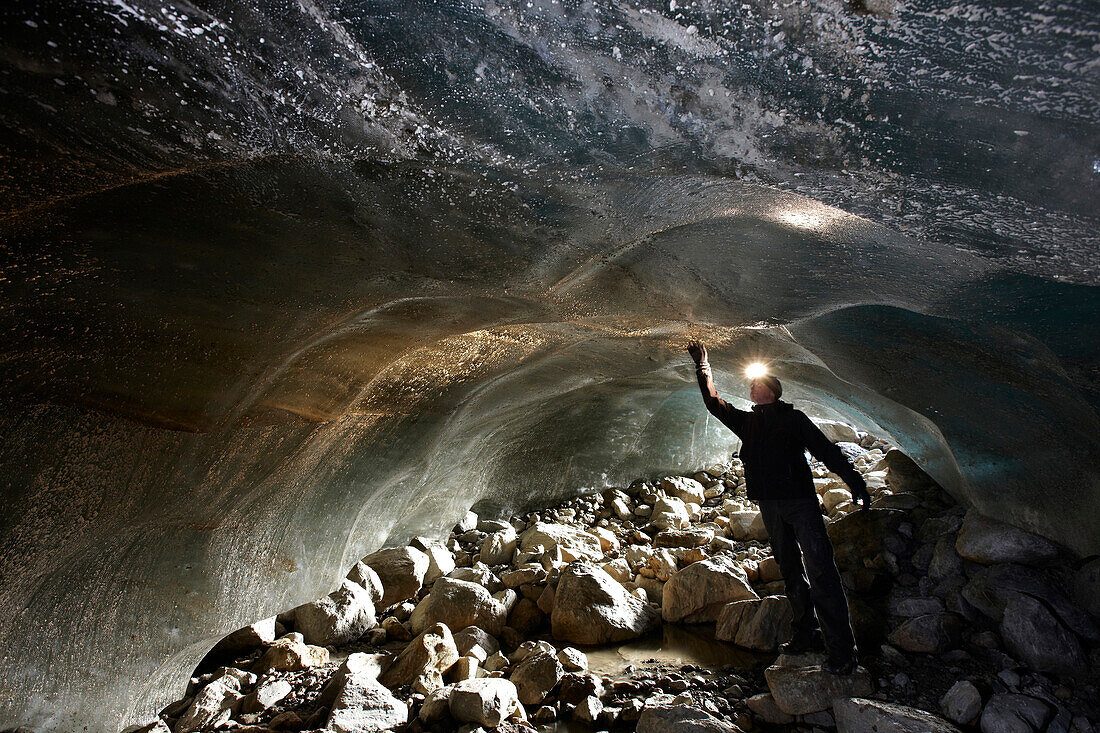 Mann mit Stirnlampe untersucht Eishöhle im Gletscher, Kurzras, Schnalstal, Südtirol, Alto Adige, Italien