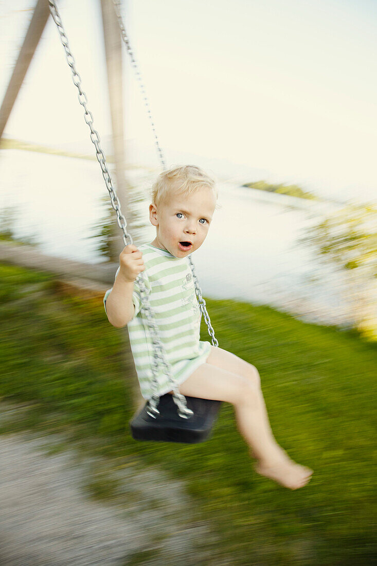 Boy swinging, Uffing am Staffelsee, Upper Bavaria, Bavaria, Germany