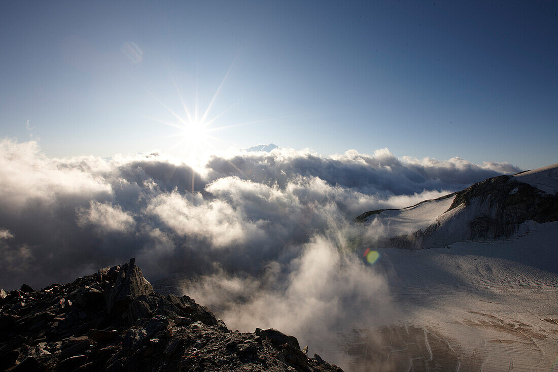 View over cloud-covered valley in sunrise, Saas-Fee, Canton of Valais, Switzerland