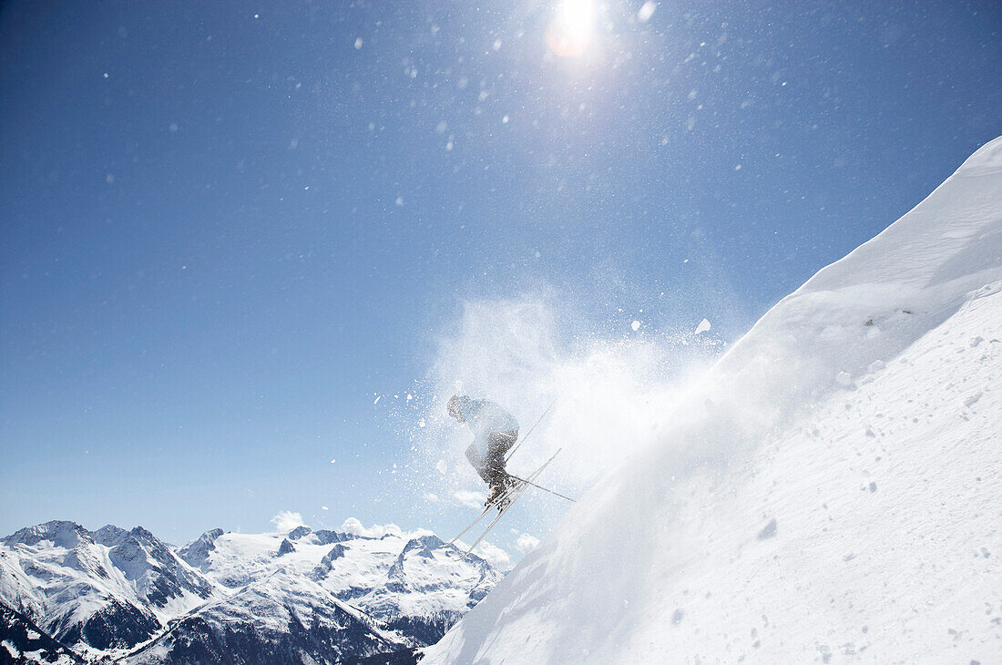 Skifahrer springt über Wechte, Disentis, Surselva, Graubünden, Schweiz