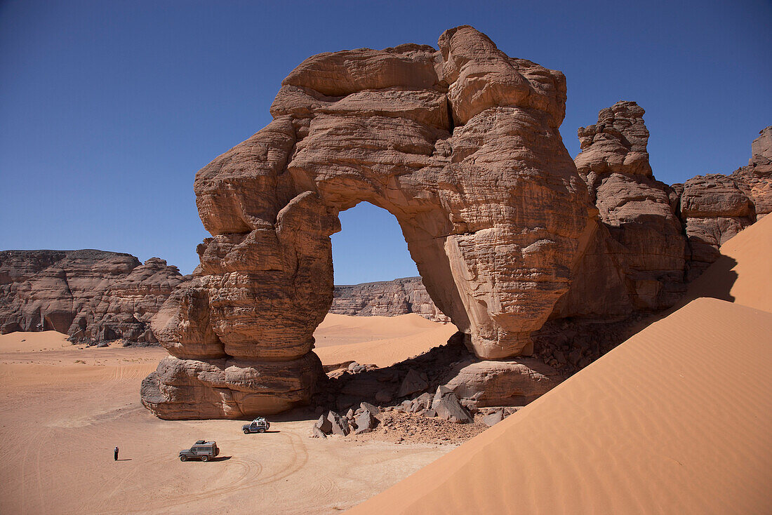 Off-road vehicles near a natural arch, Tadrart Acacus, Ghat District, Lybia