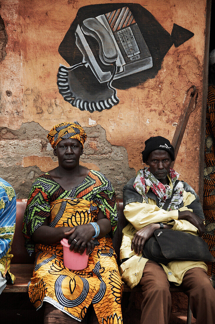 Persons sitting in front of phone store, Yanfolila, Sikasso Region, Mali