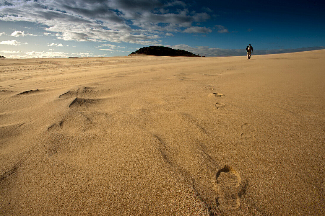 Person walking along the Thurra sand dunes, Croajingolong National Park, Victoria, Australia
