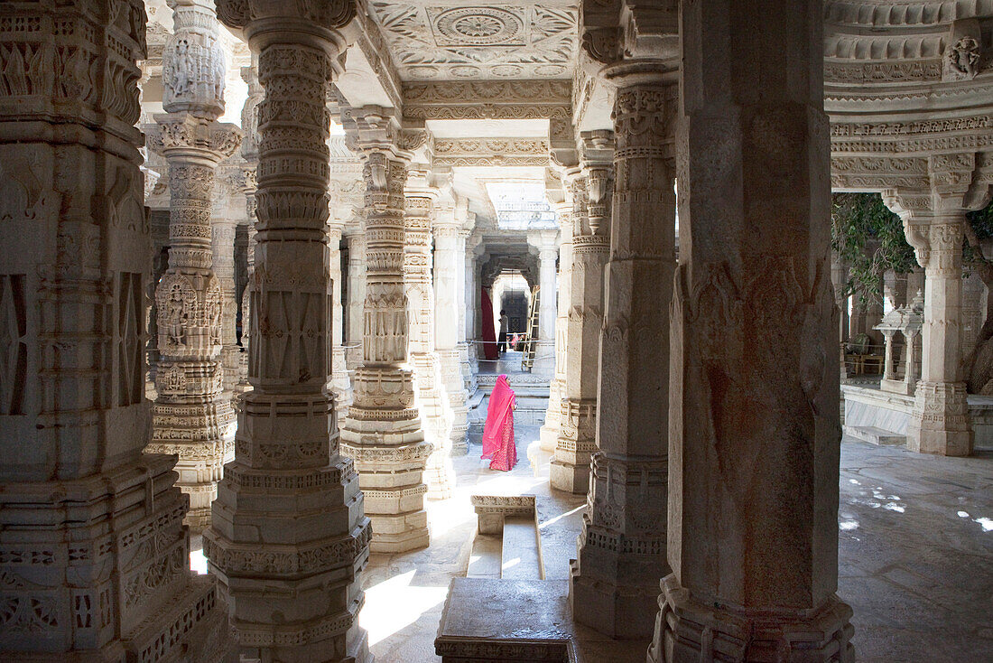 Inderin mit Sari zwischen den Säulen des jainistischen Haupttempels Chaumukha Mandir, Ranakpur, Rajasthan, Indien