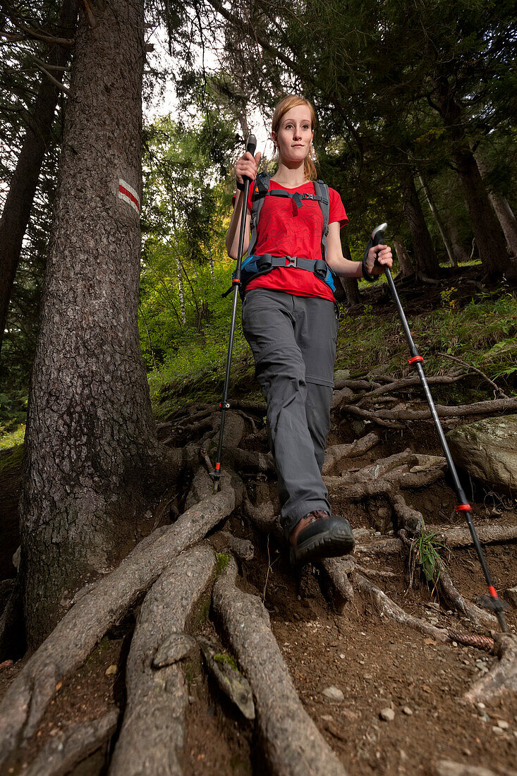 Young woman with hiking stickes, Bergell, Canton of Grisons, Switzerland