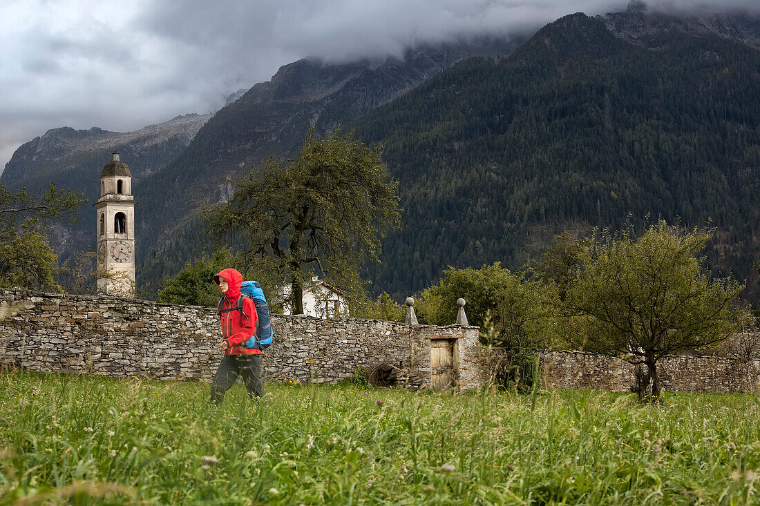 Junge Frau mit Rucksack wandert, Soglio, Bergell, Kanton Graubünden, Schweiz