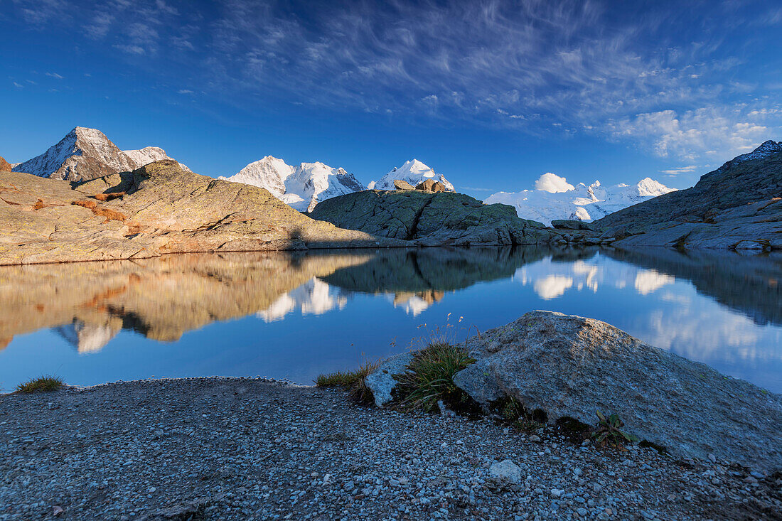 Reflection of Bernina Range on mountain lake, Val Roseg, Engadin, Canton of Grisons, Switzerland
