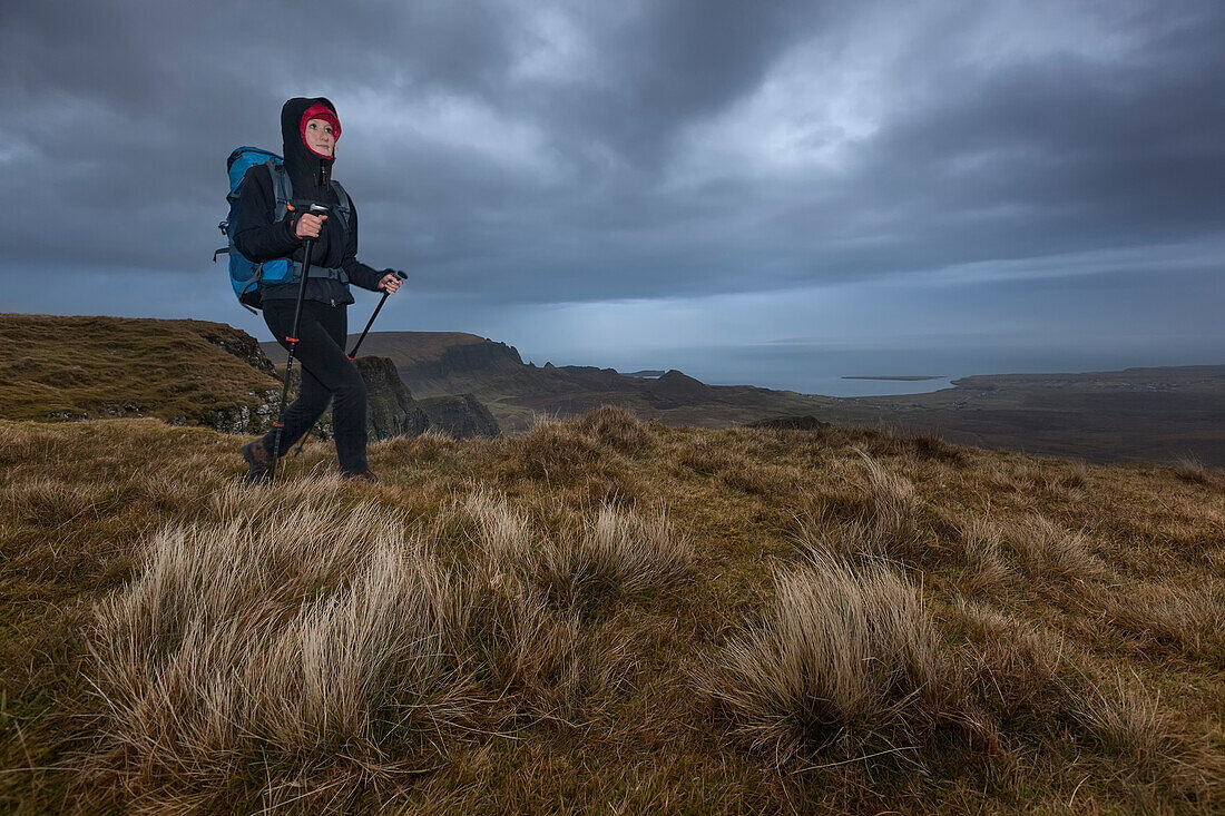 Young woman hiking in rain, Quiraing, Trotternish peninsula, Isle of Skye, Scotland, United Kingdom