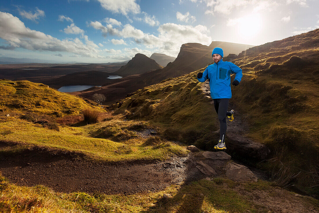 Junger Mann läuft über einen Wanderweg, Quiraing, Trotternish Halbinsel, Isle of Skye, Schottland, Großbritannien