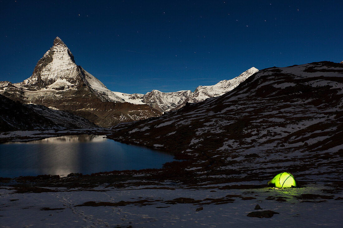 Illuminated tent at lake Riffelsee, Matterhorn in background, Zermatt, Canton of Valais, Switzerland