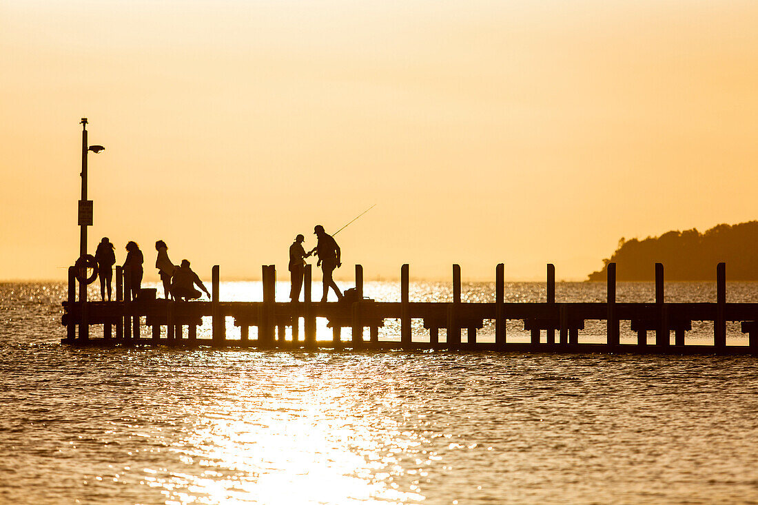 People on a jetty at Lake King in sunset, Metung, Victoria, Australia