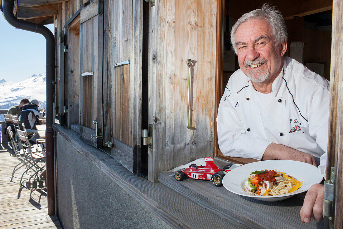 Cook with a plate of spaghetti Regazzoni, mountain inn Piz Scalottas, Lenzerheide, Scharans, Canton of Graubuenden, Switzerland