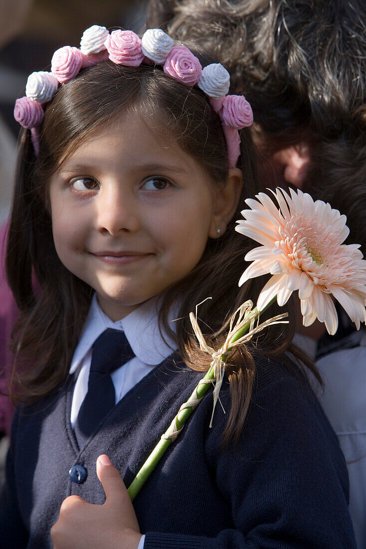 Girl with floral headdress, holding a flower at the childrens parade at the Madeira Flower Festival, Funchal, Madeira, Portugal