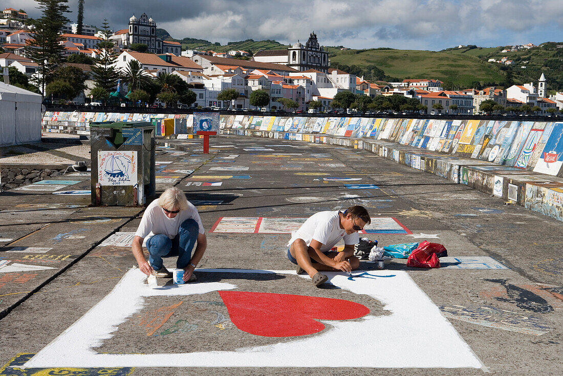 Sailors painting murals, jetty covered with murals by yacht crews during their stopover of the Atlantic Ocean, Horta, Faial Island, Azores, Portugal