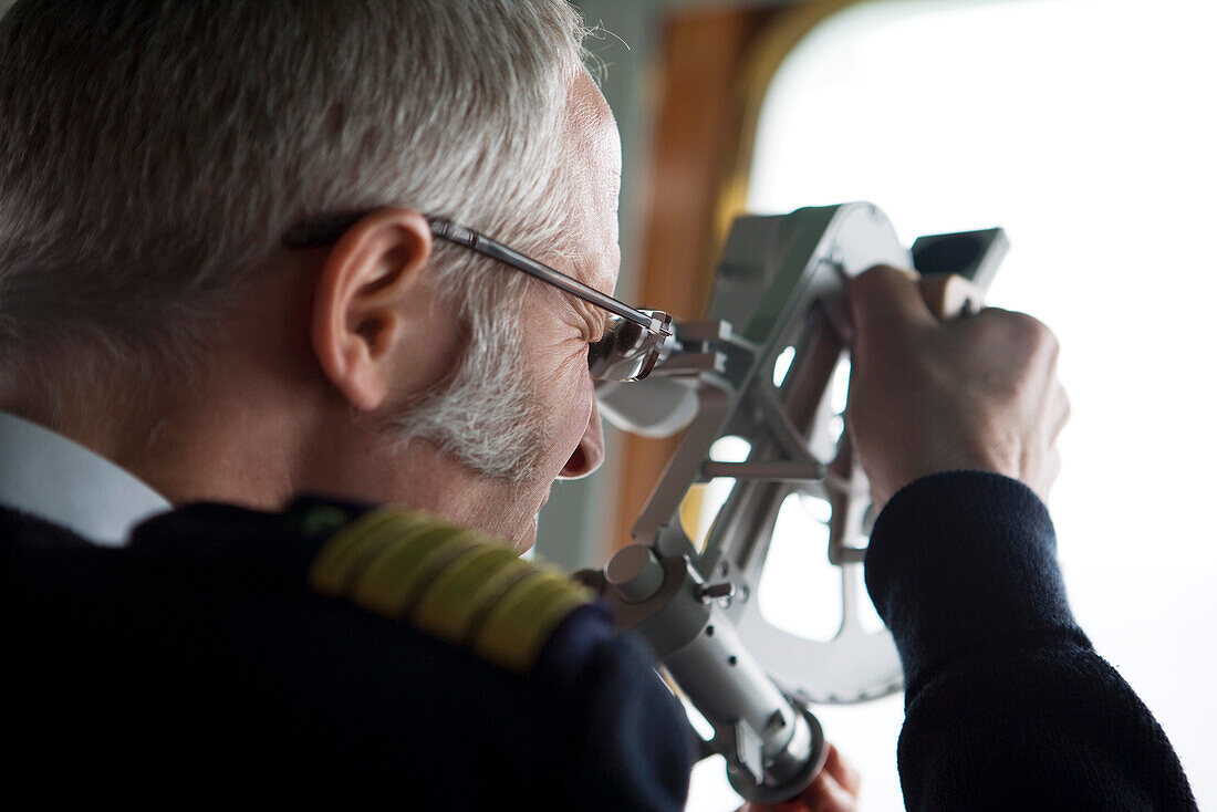 Staffkapitän Elmar Mühlebach mit Sextant an Bord von Kreuzfahrtschiff MS Deutschland (Reederei Peter Deilmann), nahe King George Island, Südliche Shetland-Inseln, Antarktis