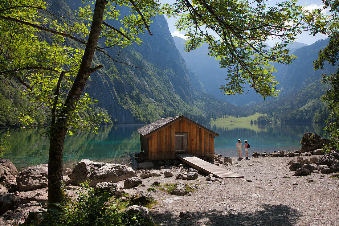 Two women at the boat house at Obersee, Koenigssee, Berchtesgaden region, Berchtesgaden National Park, Upper Bavaria, Germany