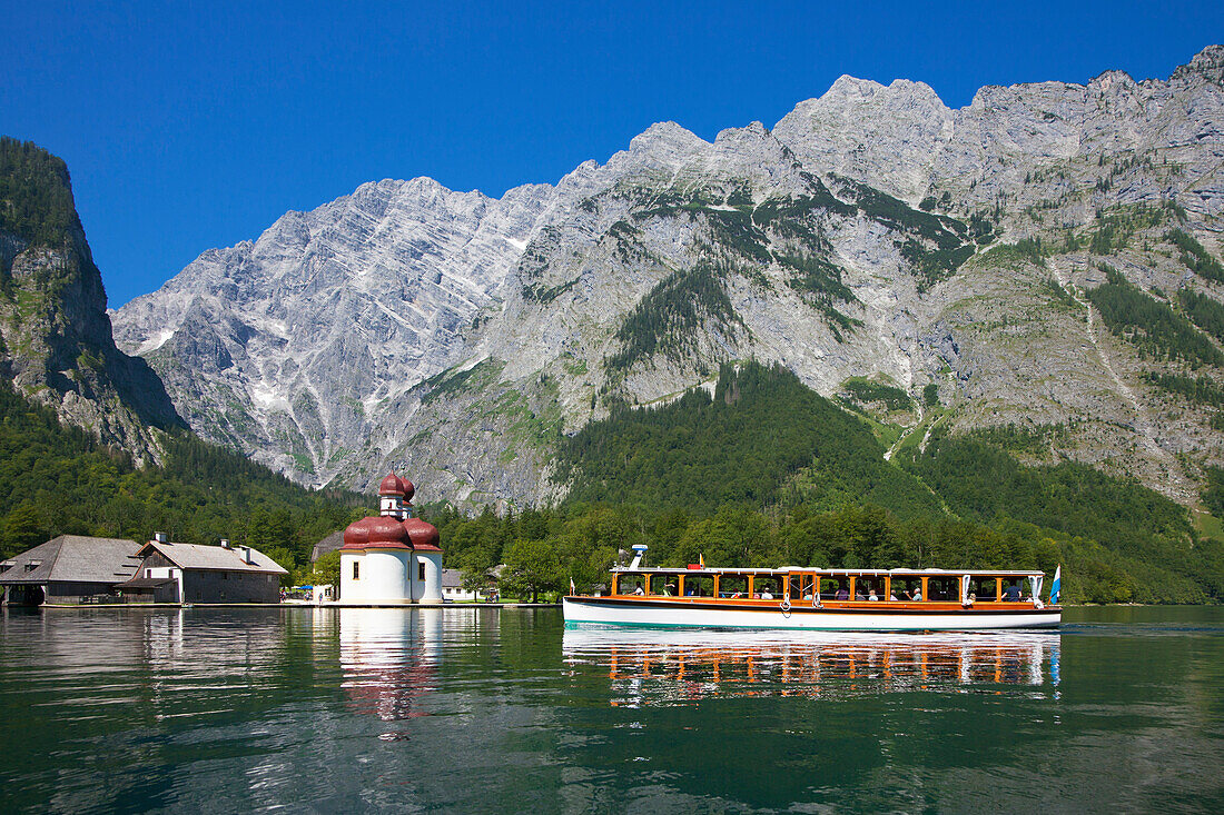 Excursion boat in front of baroque style pilgrimage church St Bartholomae, Watzmann east wall in the background, Koenigssee, Berchtesgaden region, Berchtesgaden National Park, Upper Bavaria, Germany