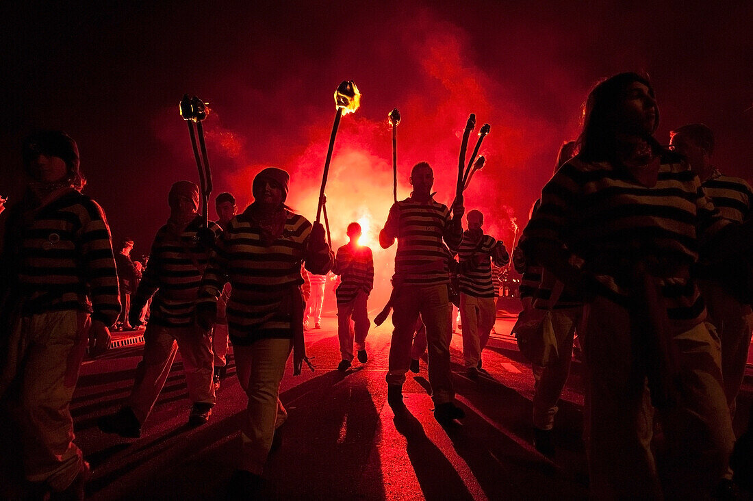Members Of Borough Bonfire Society Lit From Behind By Flare Marching In Procession At Hastings Bonfire Night, East Sussex, Uk