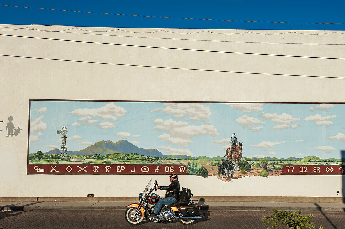 Motorcyclist Riding A Harley Davidson Passing A Cowboy Rancher Mural, Alpine, Texas, Usa