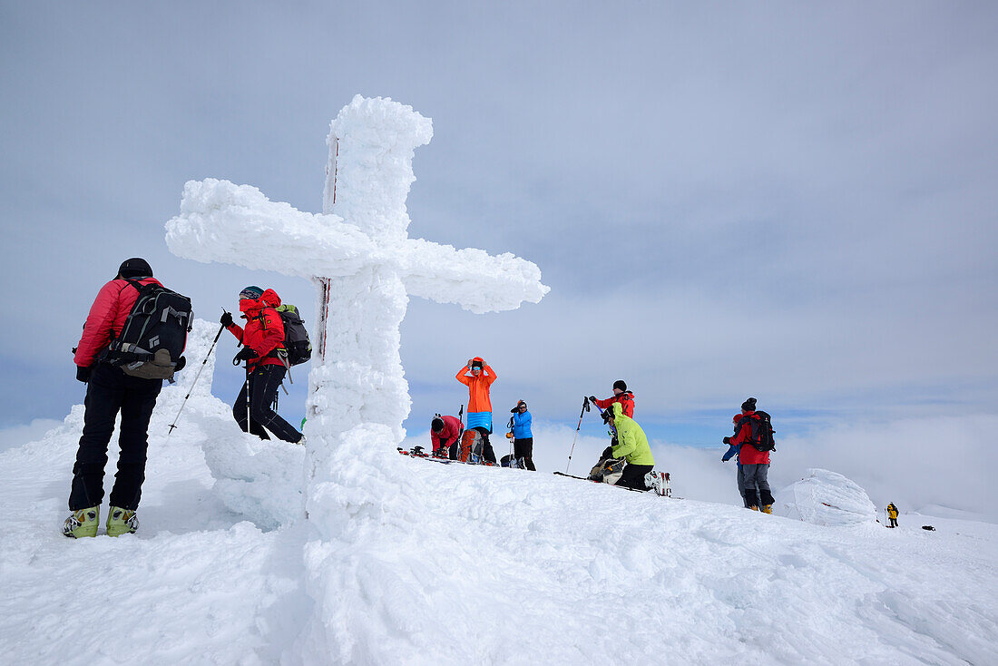 Gruppe von Tourengehern steht am Gipfel des Monte Amaro mit verschneitem Gipfelkreuz, Monte Amaro, Majella, Abruzzen, Apenninen, l 'Aquila, Italien