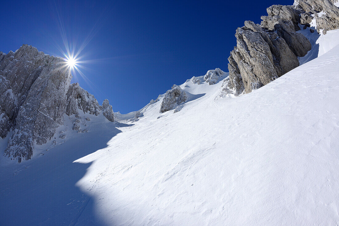Sun gleaming over the snow-covered cirque at Monte Sirente, Valle Lupara, Monte Sirente, Abruzzi, Apennines, l' Aquila, Italy