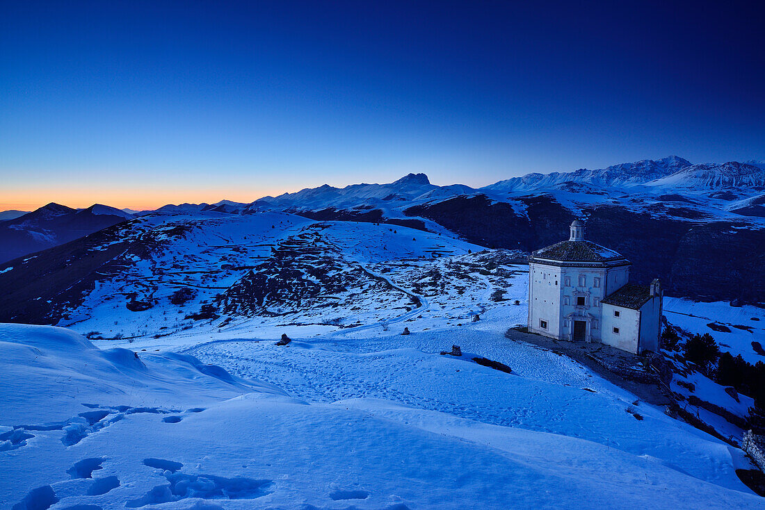 Kapelle mit Blick auf Campo Imperatore nach Sonnenuntergang, mit Gran Sasso im Hintergrund, Castel Rocca Calascio, Calascio, Abruzzen, Apenninen, l 'Aquila, Italien