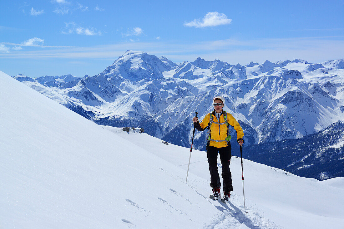 Female backcountry skier ascending to Vallatscha, Ortler in background, Ofenpass, Grisons, Switzerland