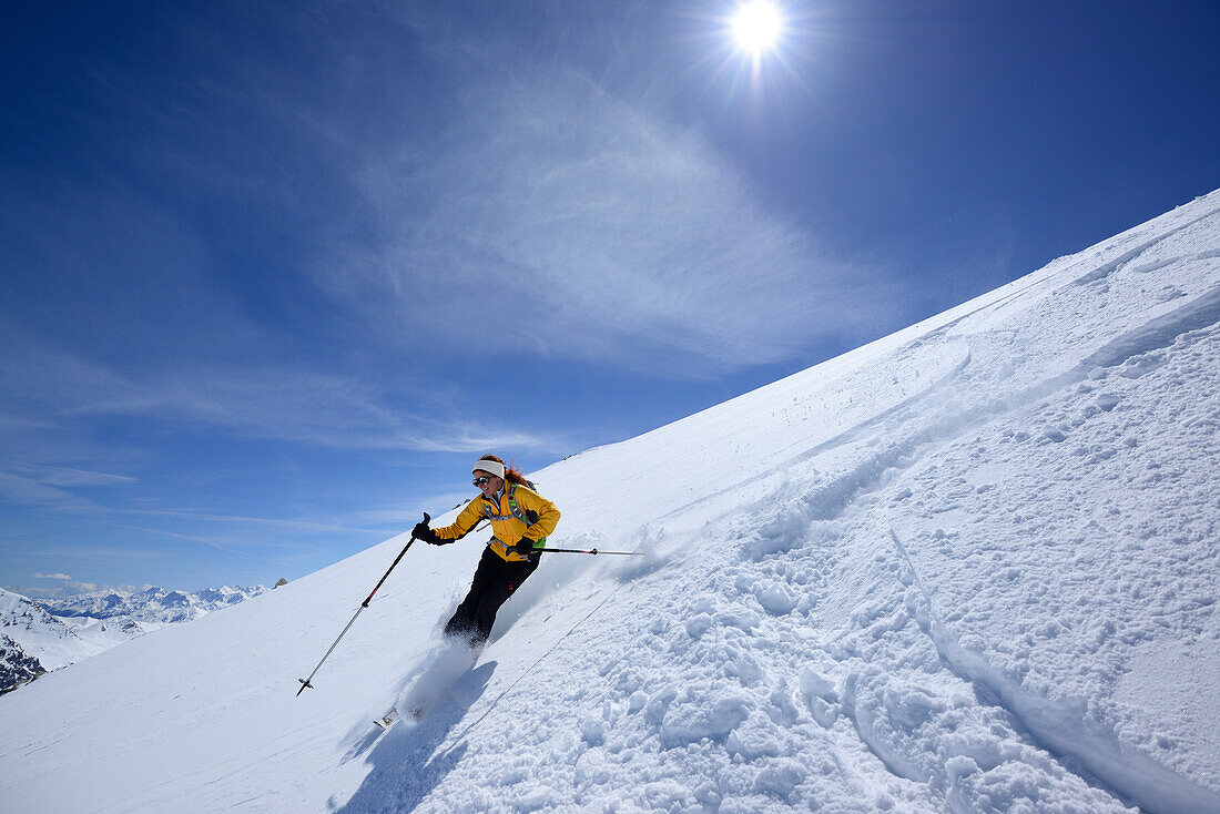 Female backcountry skier downhill skiing, Vallatscha, Sesvenna range, Ofenpass, Grisons, Switzerland