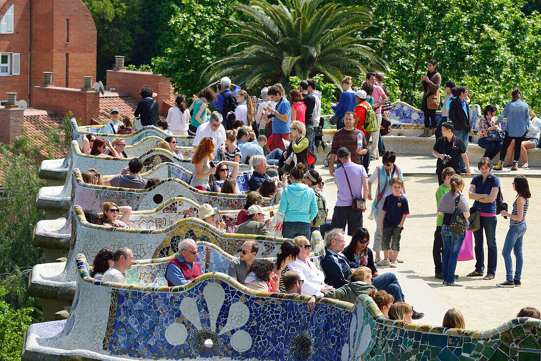 Personen sitzen auf wellenförmige Bank, Park Güell, Architekt Antoni Gaudi, UNESCO Weltkulturerbe Arbeiten von Antoni Gaudi, Modernisme, Jugendstil, Barcelona, Katalonien, Spanien