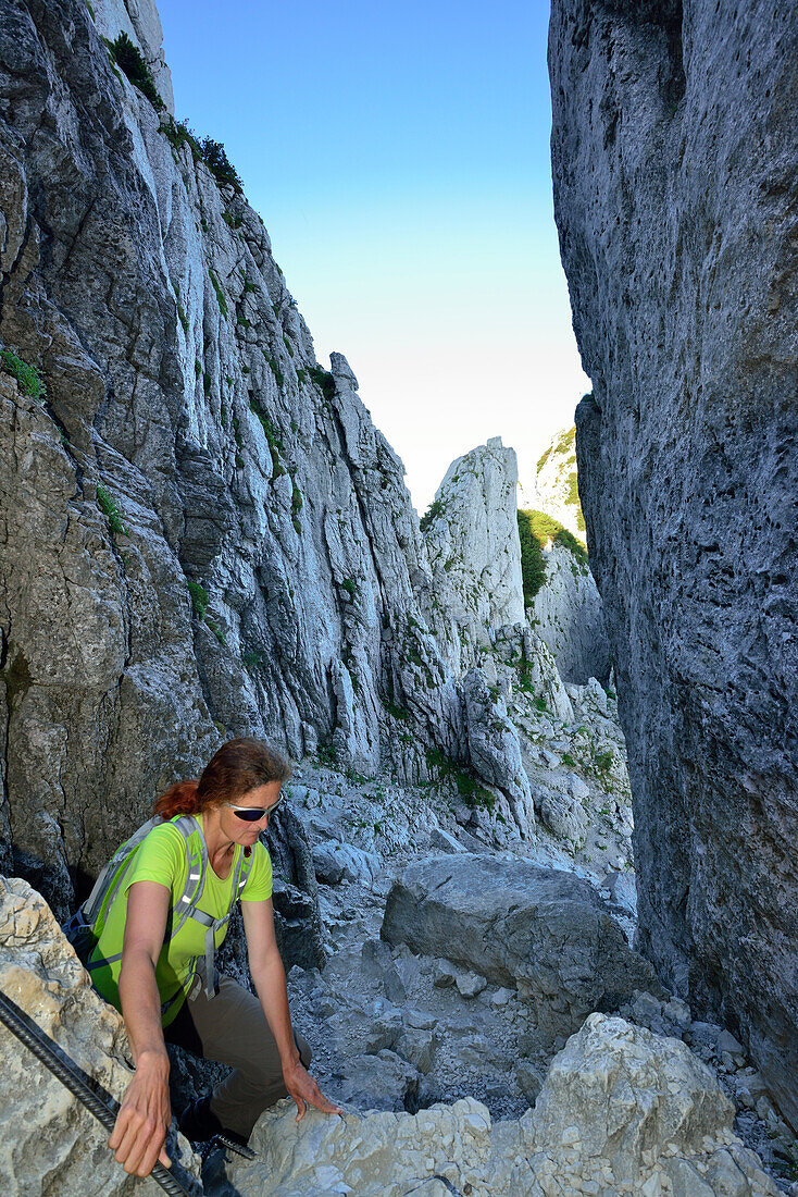 Frau steigt durch Felsschlucht Kaisersäle zur Kampenwand auf, Chiemgauer Alpen, Chiemgau, Oberbayern, Bayern, Deutschland