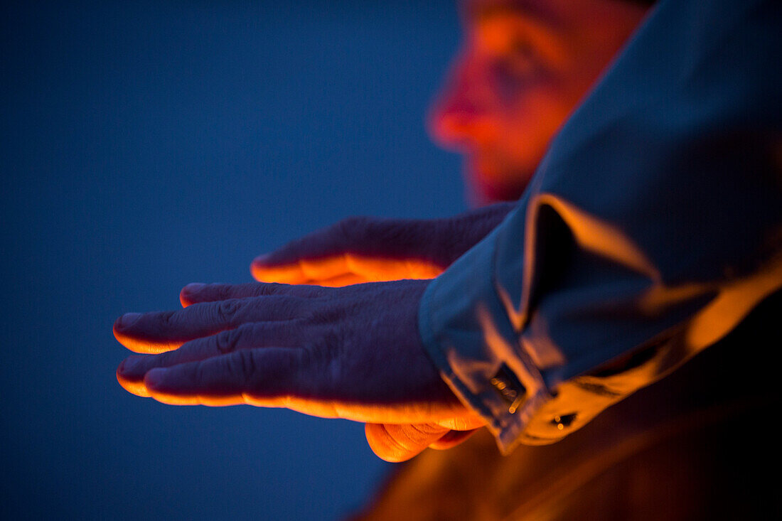 Man warming his hands over the eternal flame at the Field of Mars, St. Petersburg, Russia, Europe