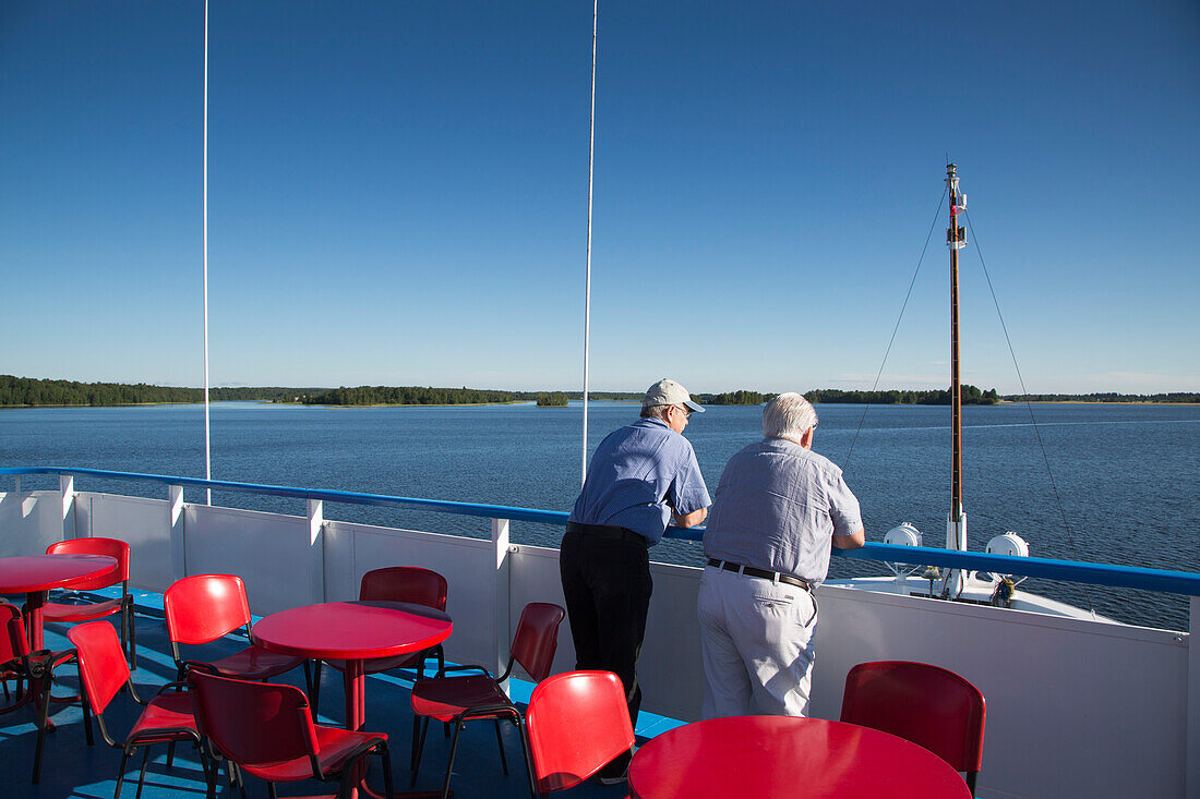 Zwei Männer an Deck von Flusskreuzfahrtschiff MS General Lavrinenkov (Orthodox Cruise Company) auf dem Onegasee, Russland, Europa