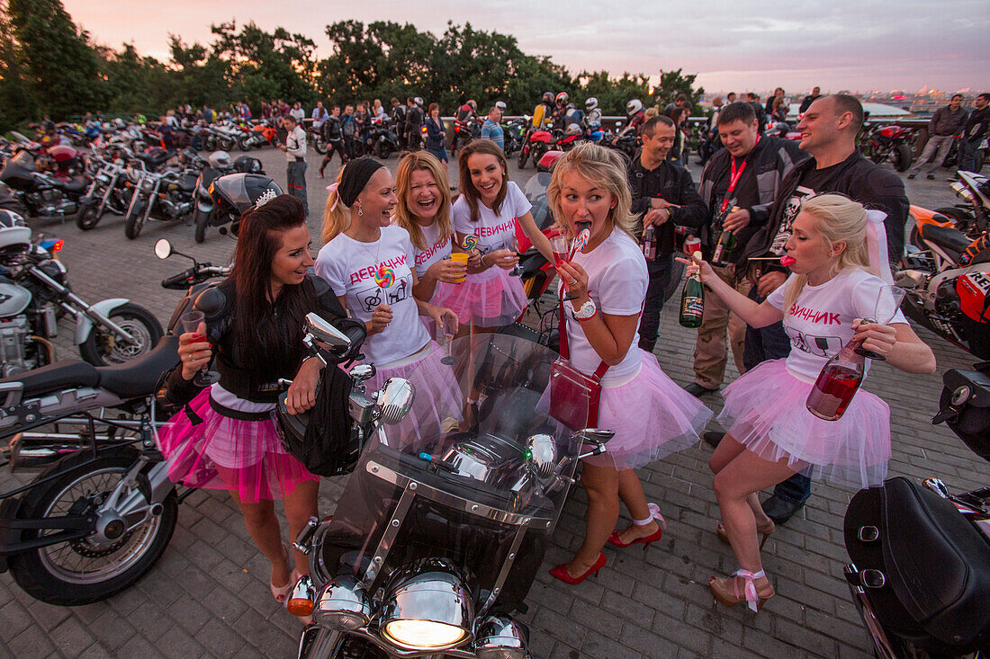 Junge Frauen feiern Junggesellinnenabschied inmitten von Motorrädern am Aussichtspunkt Sperlingsbergen, Moskau, Russland, Europa