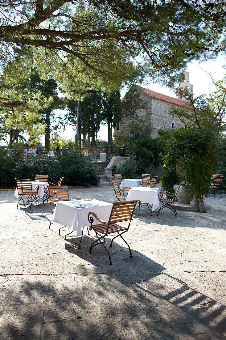 Coffee tables on the Piazza under trees, Aman Sveti Stefan, Sveti Stefan, Montenegro