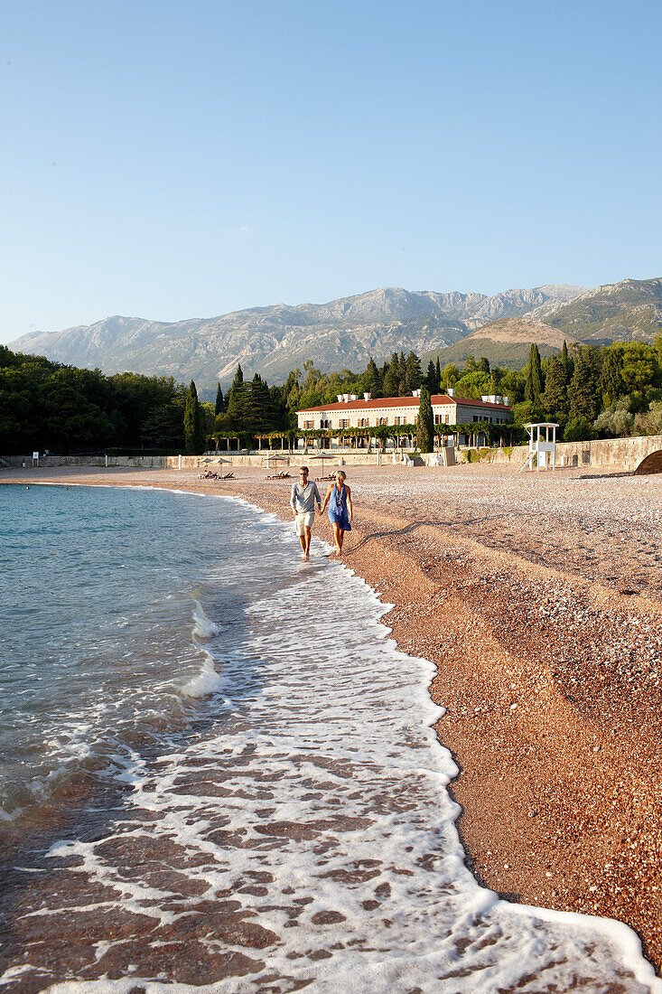 Couple at beach, Villa Milocer in background, Aman Sveti Stefan, Sveti Stefan, Budva, Montenegro