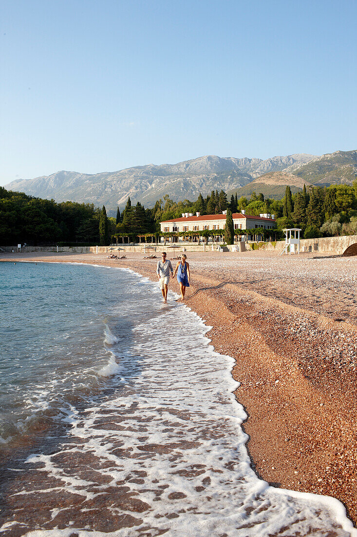 Paar am Strand, Villa Milocer im Hintergrund, Aman Sveti Stefan, Sveti Stefan, Budva, Montenegro