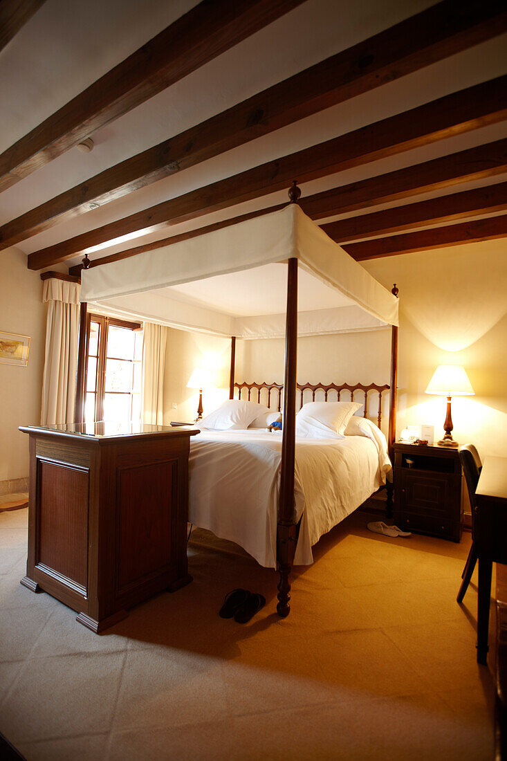 Himmelbett in einer Suite mit Deckenbalken und Mobiliar im mallorquinischen Stil, Hotel La Residencia, Deia, Mallorca, Spanien
