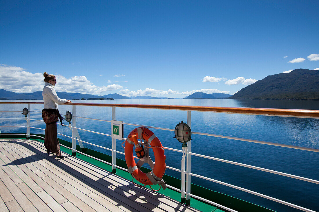 Woman at the railing of cruise ship MS Deutschland (Reederei Peter Deilmann), Chilean fjords, Magallanes y de la Antartica Chilena, Patagonia, Chile