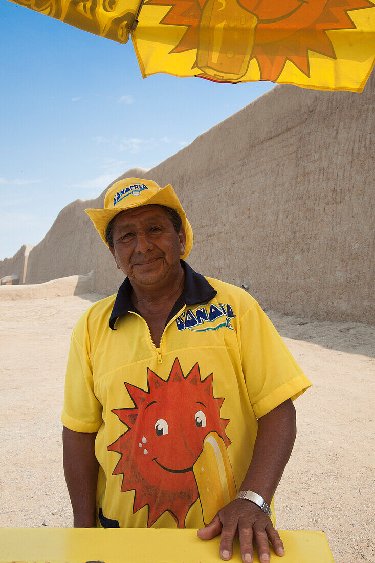 Ein freundlicher Eisverkäufer vor den archäologischen Ruinen des Chimu Reiches Chan Chan (UNESCO Weltkulturerbe), Trujillo, La Libertad, Peru, Südamerika