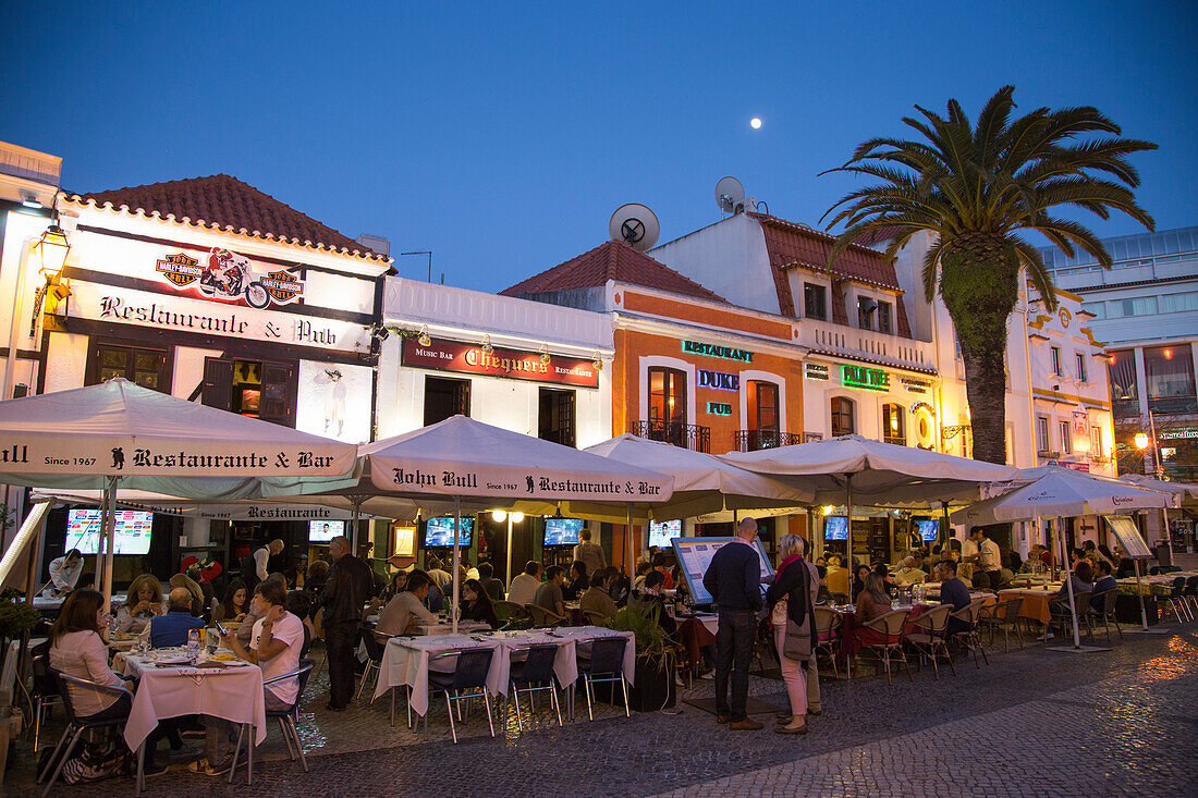 Restaurants with outdoor seating at Praca Costa Pinto square at dusk, Cascais, near Lisbon, Lisboa, Portugal
