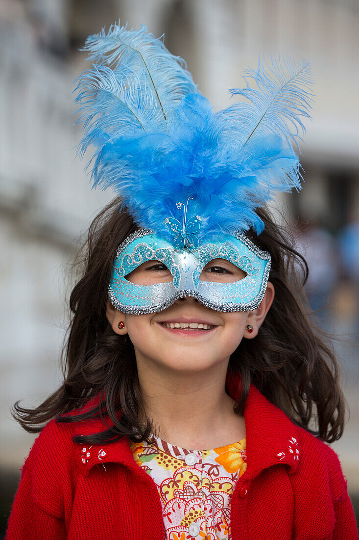 Junges Mädchen mit blauer Karnevalsmaske auf dem Markusplatz, Venedig, Venetien, Italien, Europa