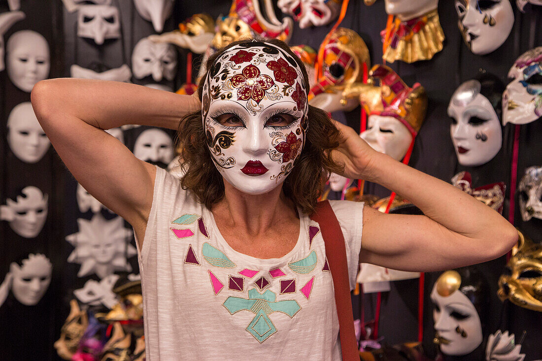 Frau mit Karnevalsmaske im Ca' Macana Maskengeschäft, Venedig, Venetien, Italien, Europa
