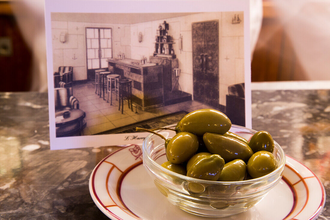 Stillleben mit Oliven und einer Postkarte mit historischer Aufnahme in Harry's Bar, Venedig, Venetien, Italien, Europa