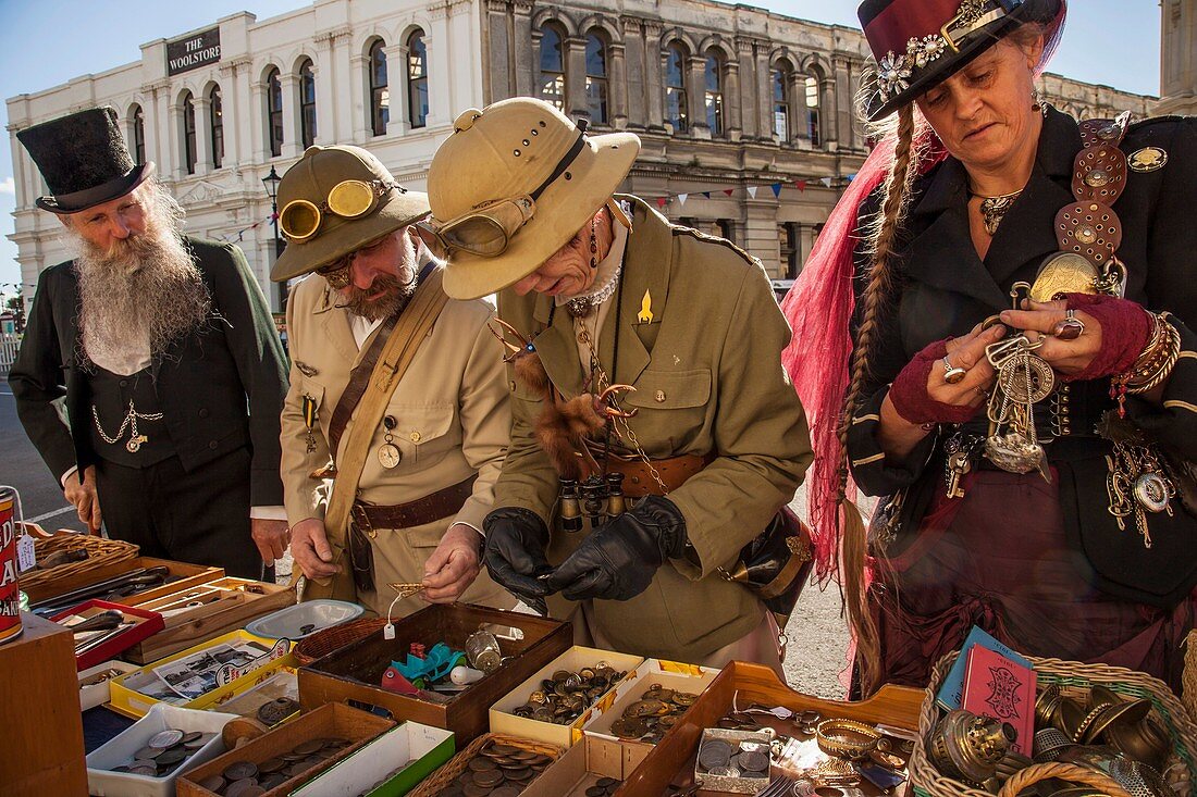 Joy of fossicking for a treasure, men and women in Victorian costume search for brass buttons, Victorian festival, historic precinct, Oamaru, Otago