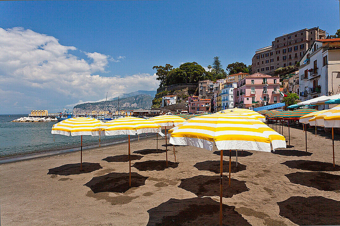 Yellow umbrellas on the sandy beach in Sorrento, Campania, Italy