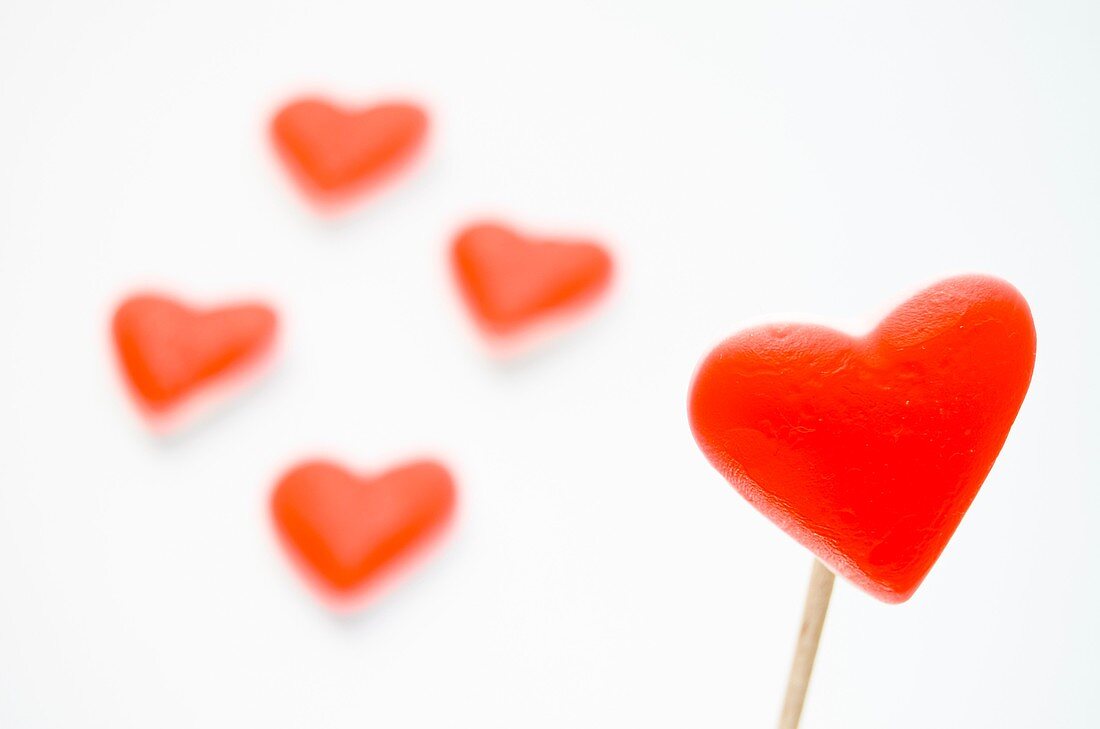 In the foreground a red heart. At the back, four red hearts on a gray background.