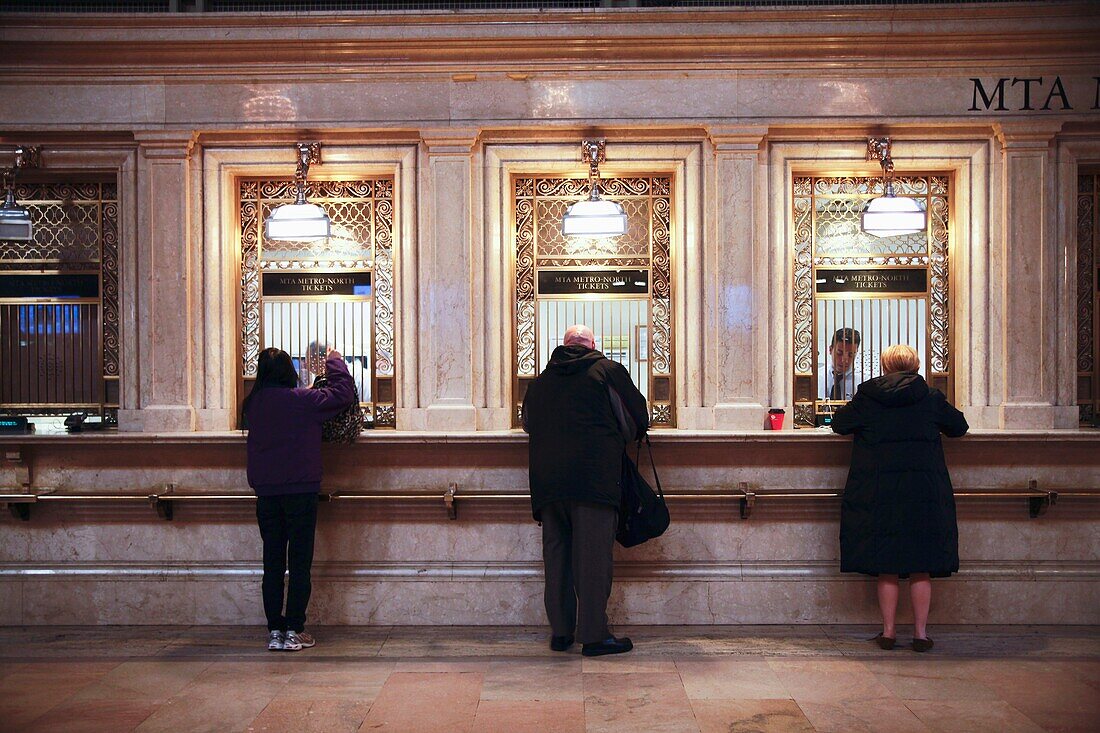 Man and Two Women Separately Purchasing MTA-Metro North Commuter Railroad Tickets at Grand Central Station, New York, NY, USA