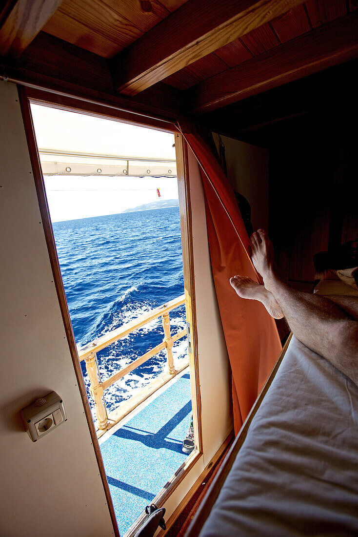 Person liegt auf einem Bett in einem Boot mit Blick aufs Meer, Hvar, Dalmatien, Kroatien